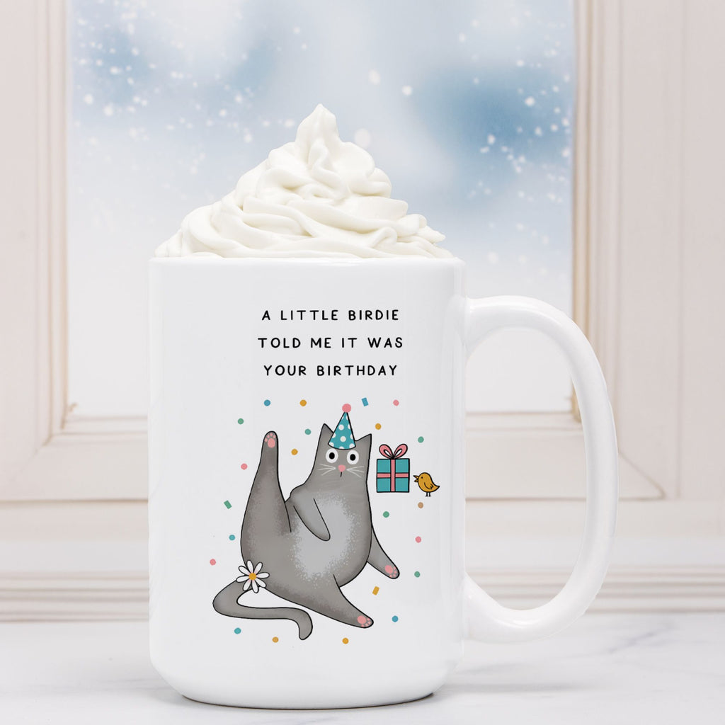 White mug with a cartoon cat and birthday text on a white background