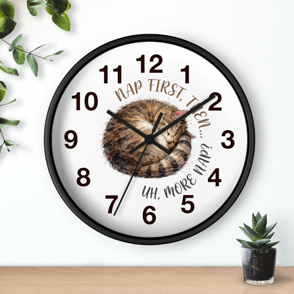 Round black wall clock with a cat illustration and humorous text on a white background