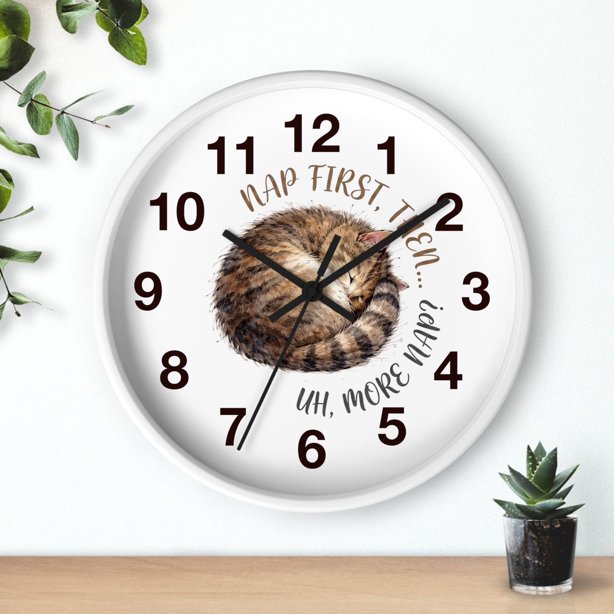 Round white wall clock with a cat illustration and humorous text on a white background