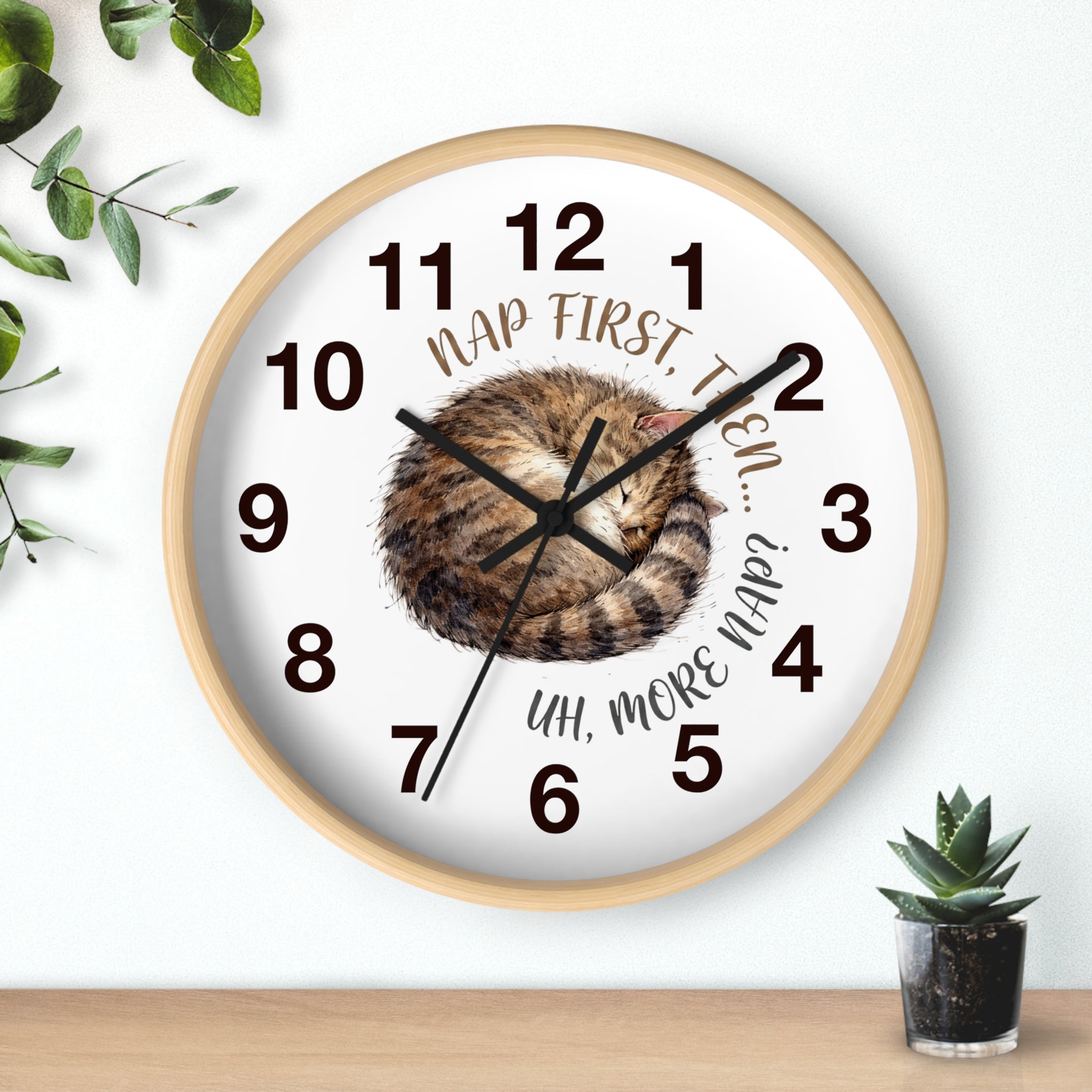 Round wood wall clock with a cat illustration and humorous text on a white background