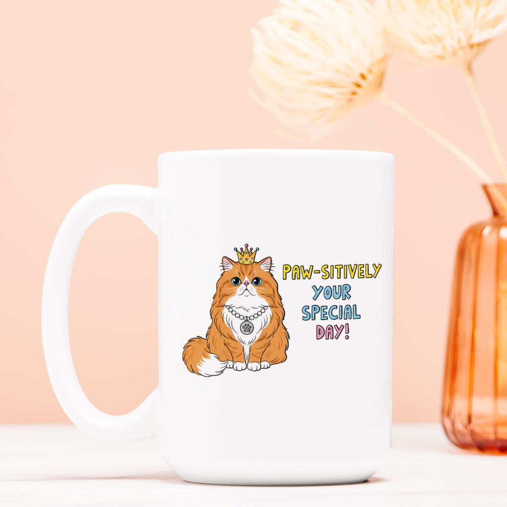 White mug with a cat illustration and birthday text on a peach background