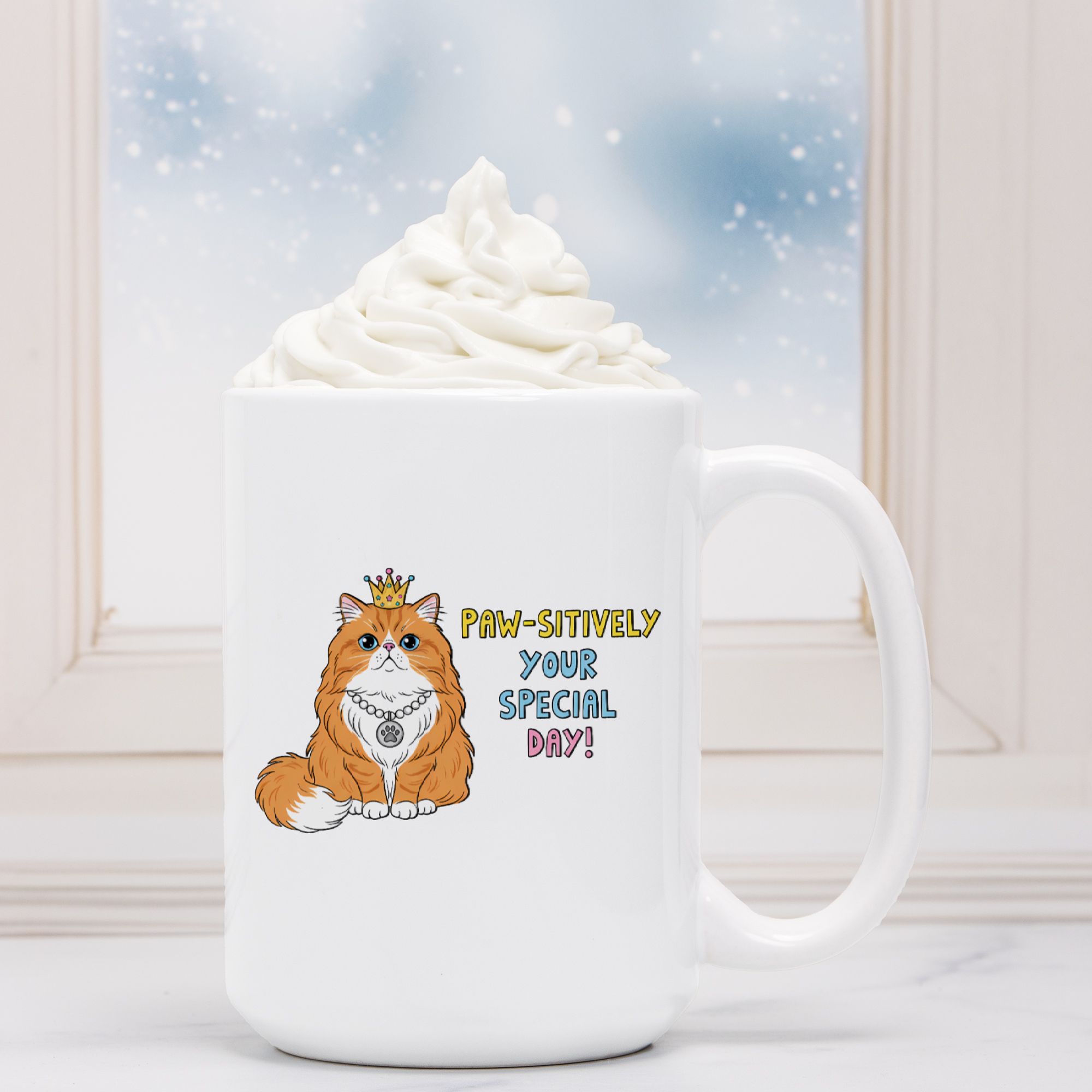 White mug with a cat illustration and text 'Paw-sitively Your Special Day!' next to a hot chocolate with whipped cream.