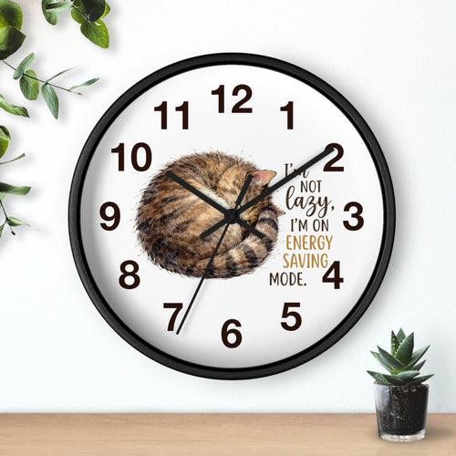 Round black wall clock with a cat illustration and humorous text on a white background