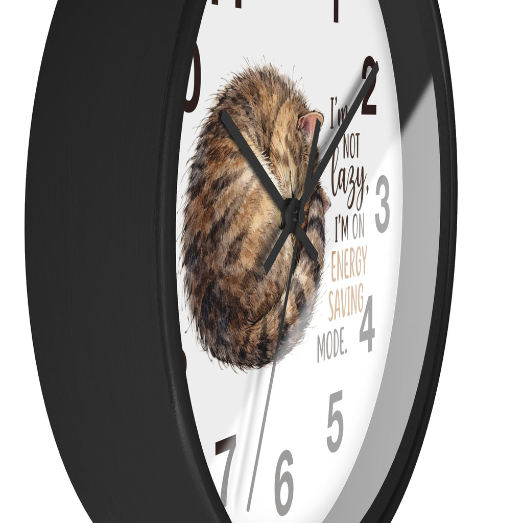 Side view of a round black wall clock with a cat illustration and humorous text on a white background