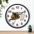 Round black wall clock with a cat illustration and humorous text on a white background