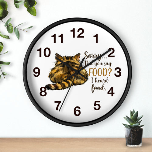 Round black wall clock with a cat illustration and humorous text on a white background
