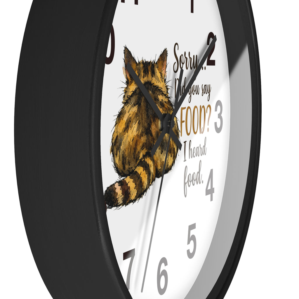 Side view of a round black wall clock with a tabby cat illustration and humorous text on a white background