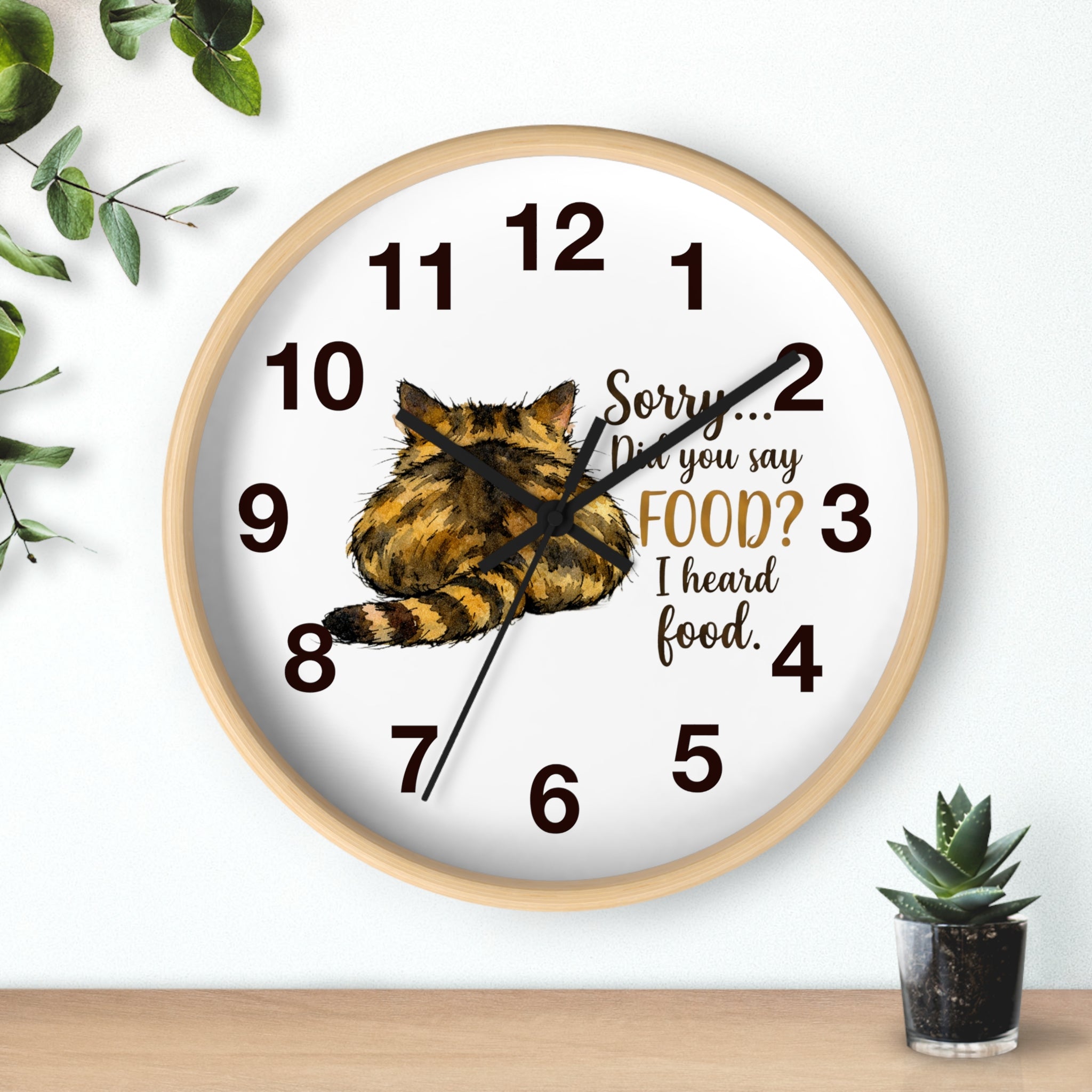 Round wood wall clock with a cat illustration and humorous text on a white background