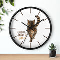Round black wall clock with a cat design and 'Catitude Served Daily' text, placed on a surface with plants.