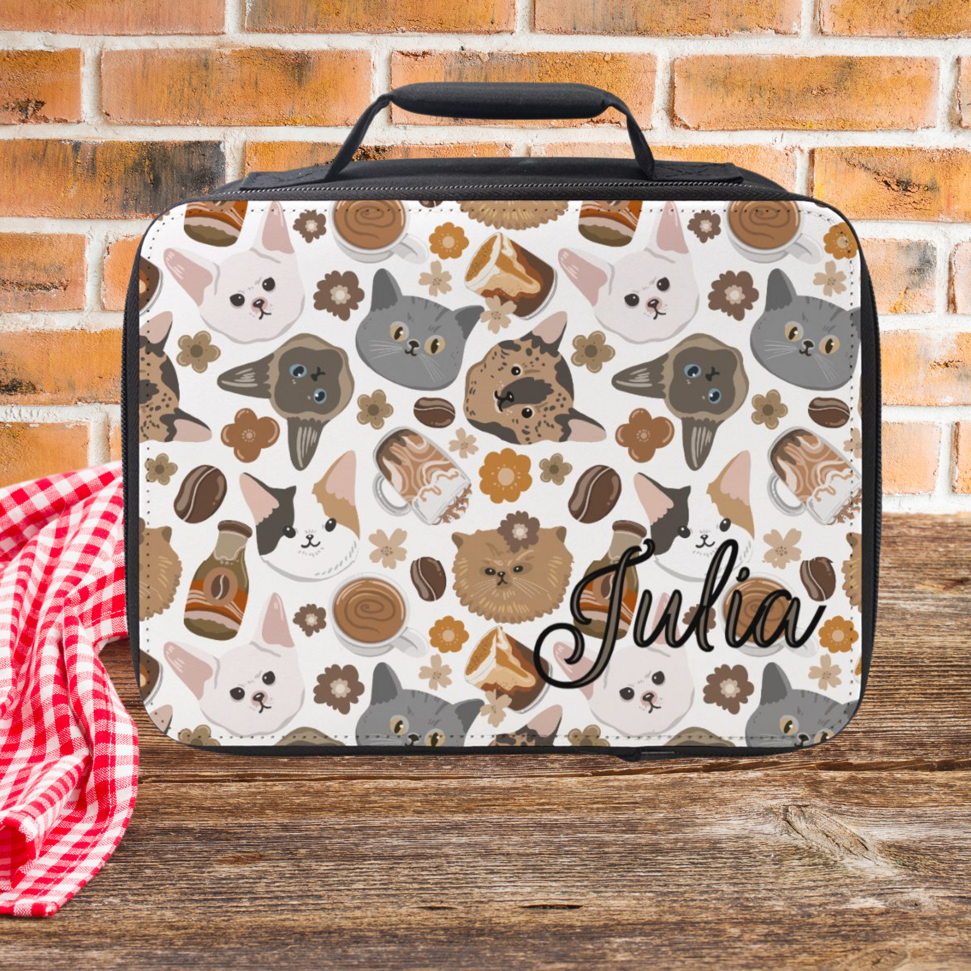 Lunch bag with cat pattern and 'Julia' text against a brick wall background