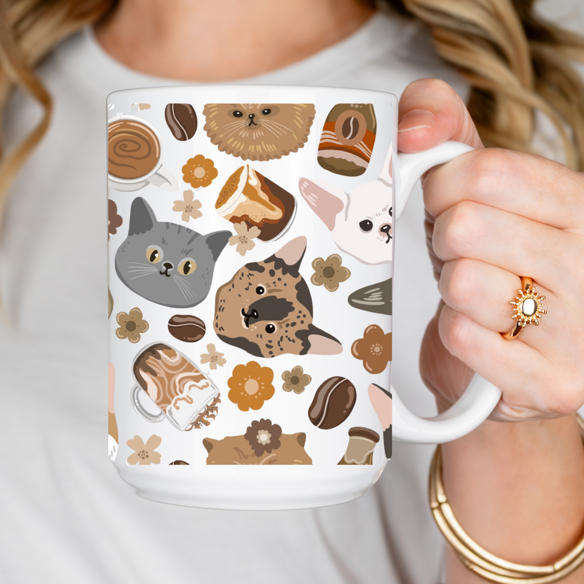Person holding a mug with cat-themed design