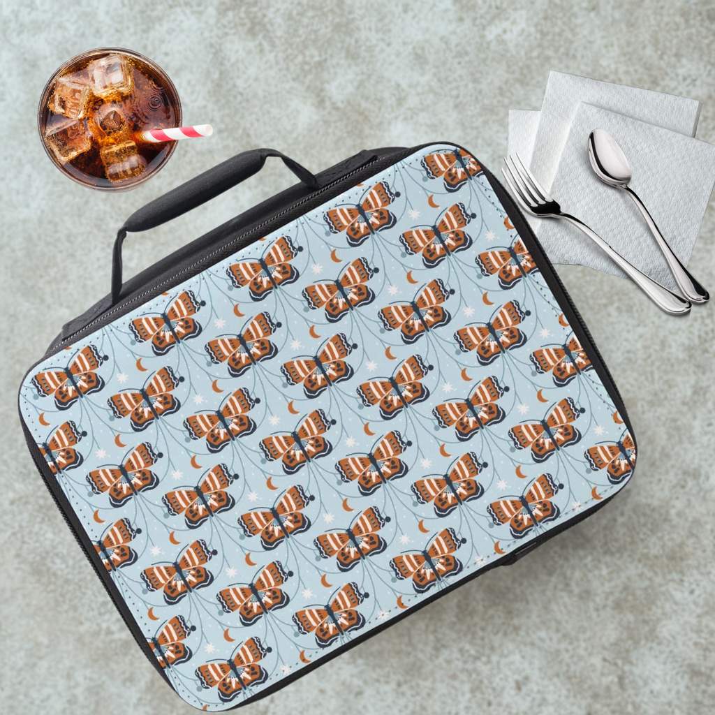 Lunch bag with butterfly pattern on a cafeteria table with a drink and utensils.