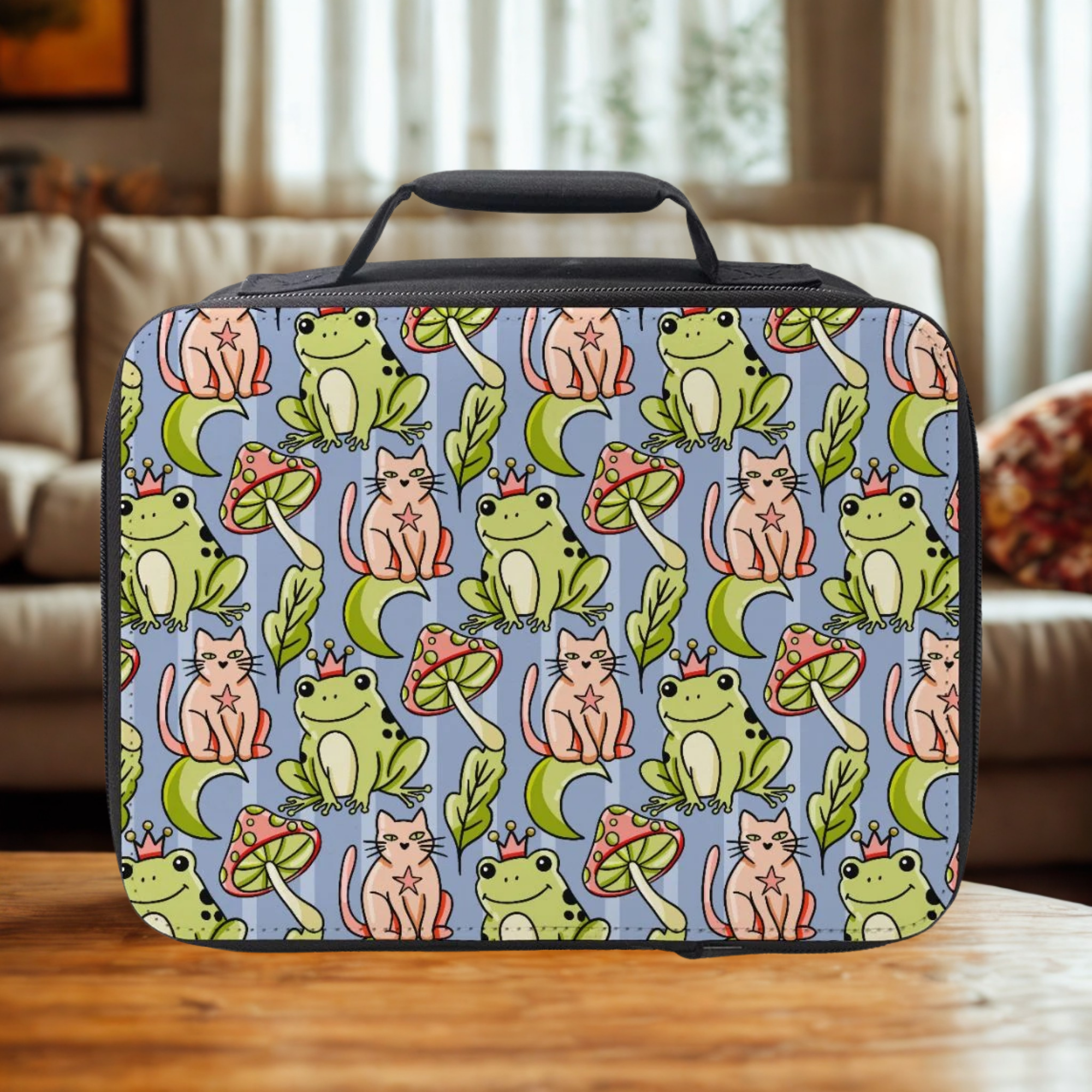  insulated lunch bag with frog and cat pattern on a wooden coffee table in a cozy living room.