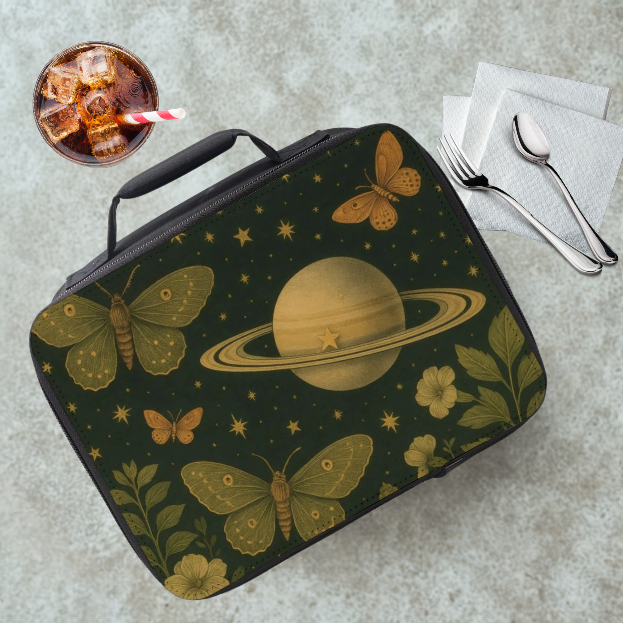 Lunch bag with space-themed design featuring planets and moths on a concrete surface.