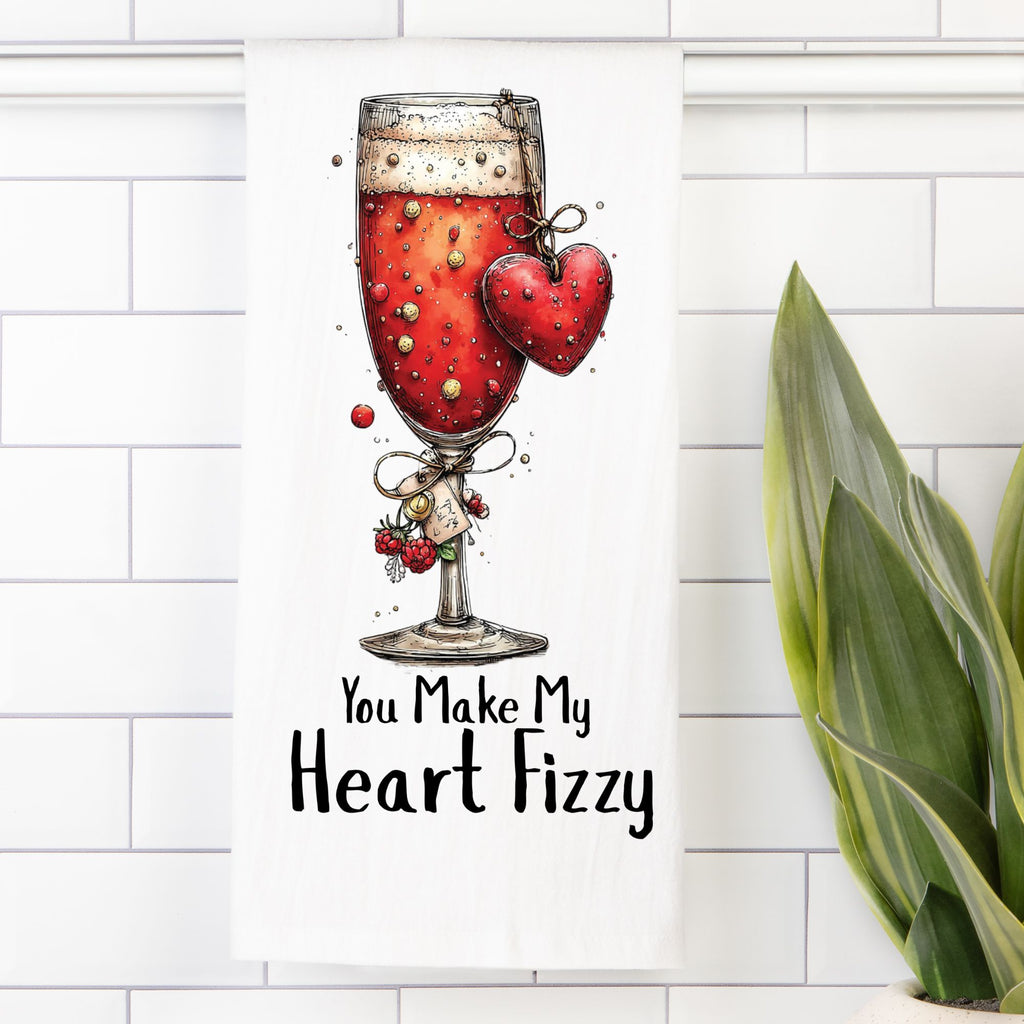 Tea Towel with Illustration of a glass of red liquid with a heart and text 'You Make My Heart Fizzy' on a white tiled background.