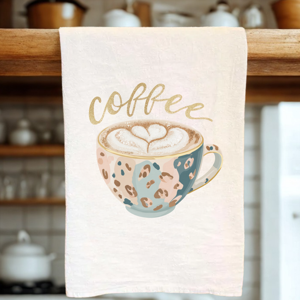 Kitchen towel with a coffee cup design and 'coffee' text on a wooden rack.