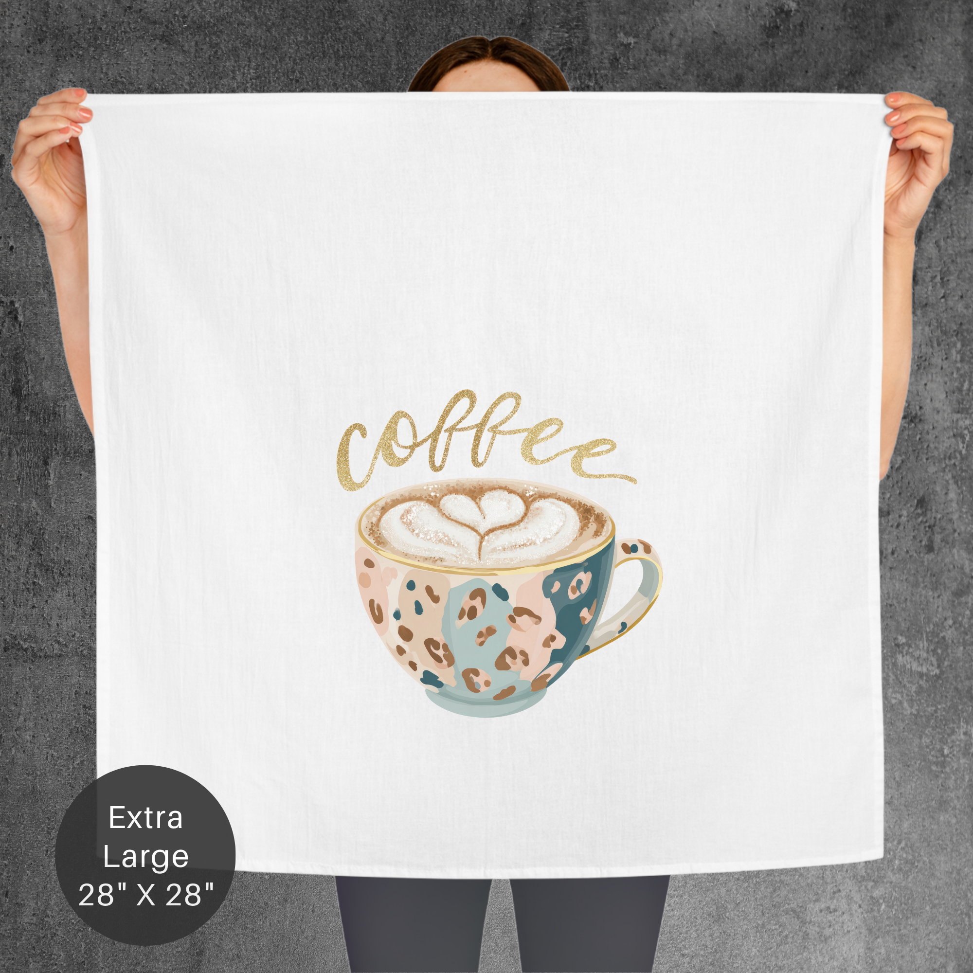 Person holding a large towel with a glitter coffee-themed design against a gray background