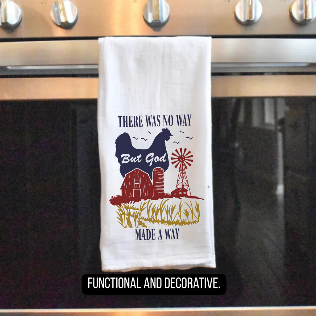 Decorative tea towel with farm-themed design hanging on a stove handle.