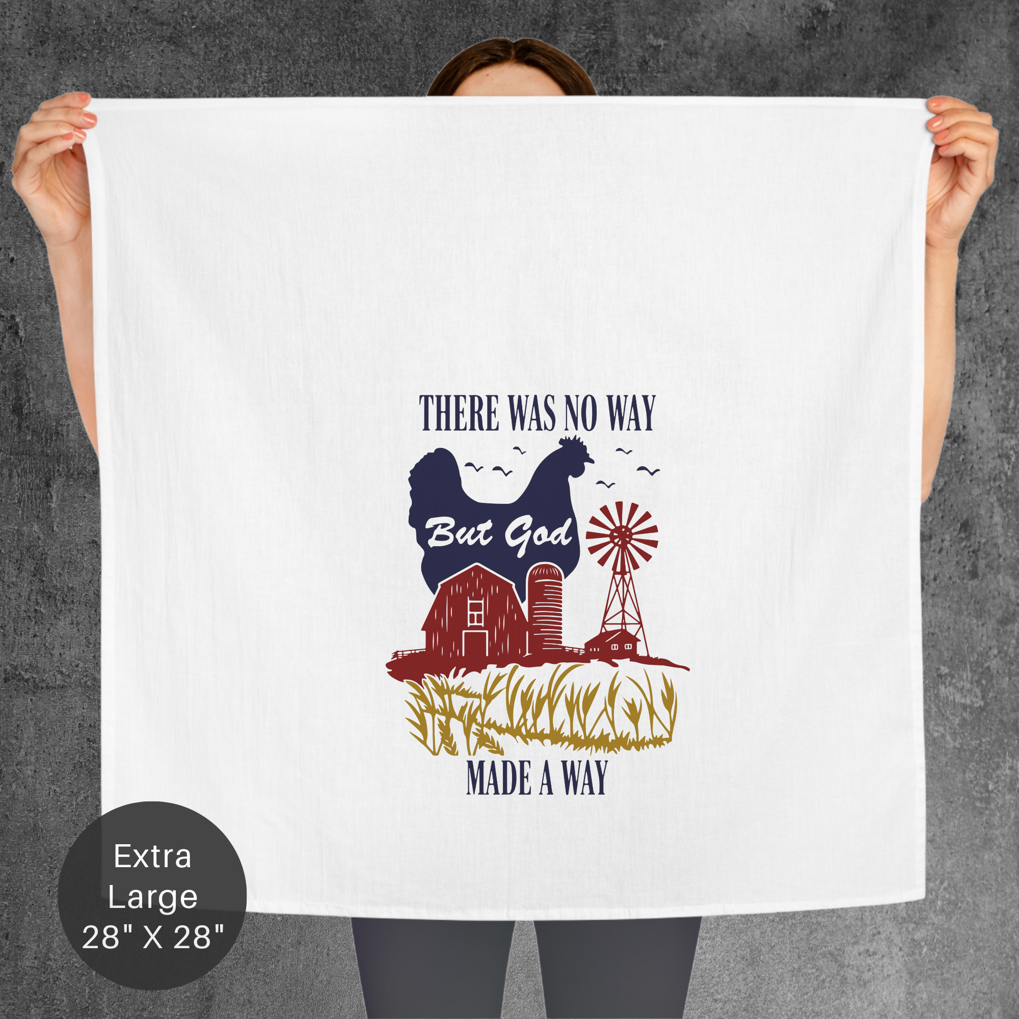 Person holding a large white tea towel with a graphic design and text on a gray background