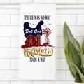 Decorative tea towel with a chicken, barn, windmill, and text on a white tiled wall.