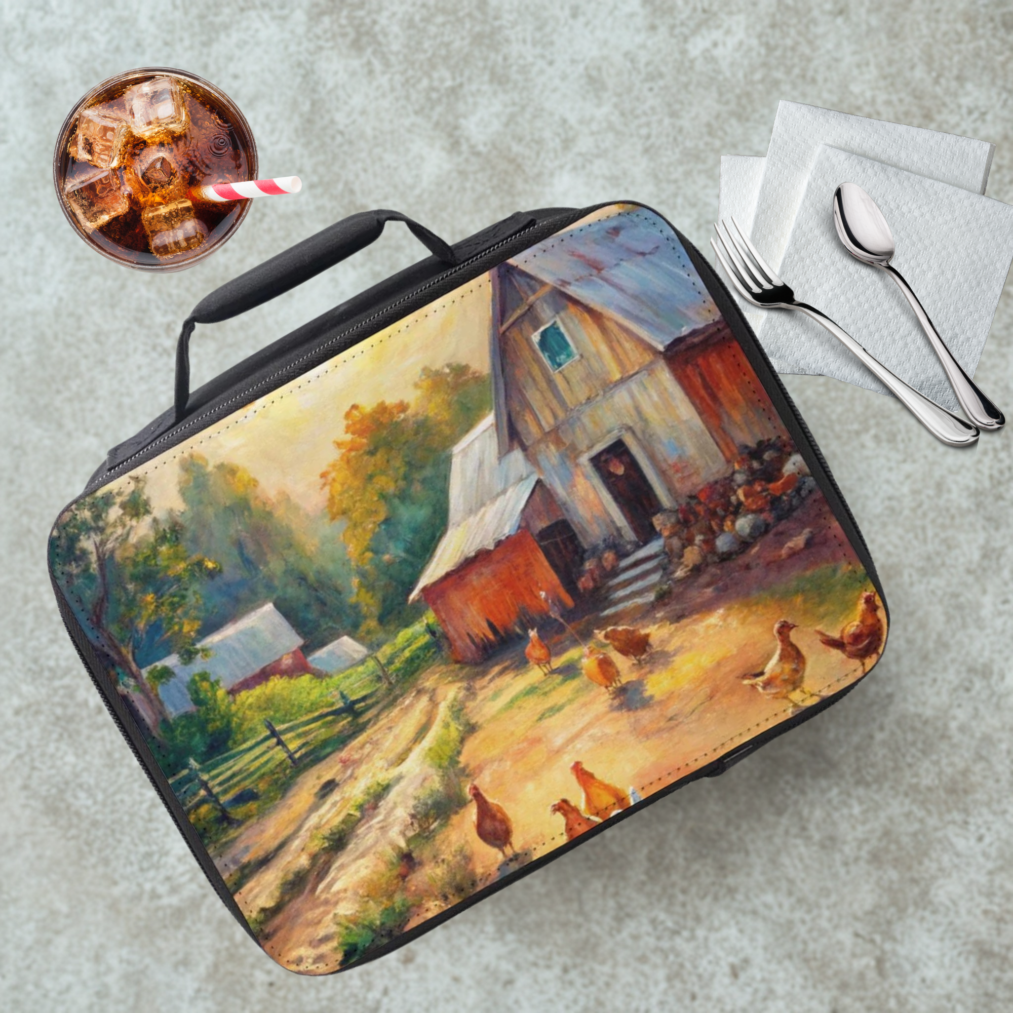 Lunch bag with a farm scene design on a cafeteria table with a drink and utensils.