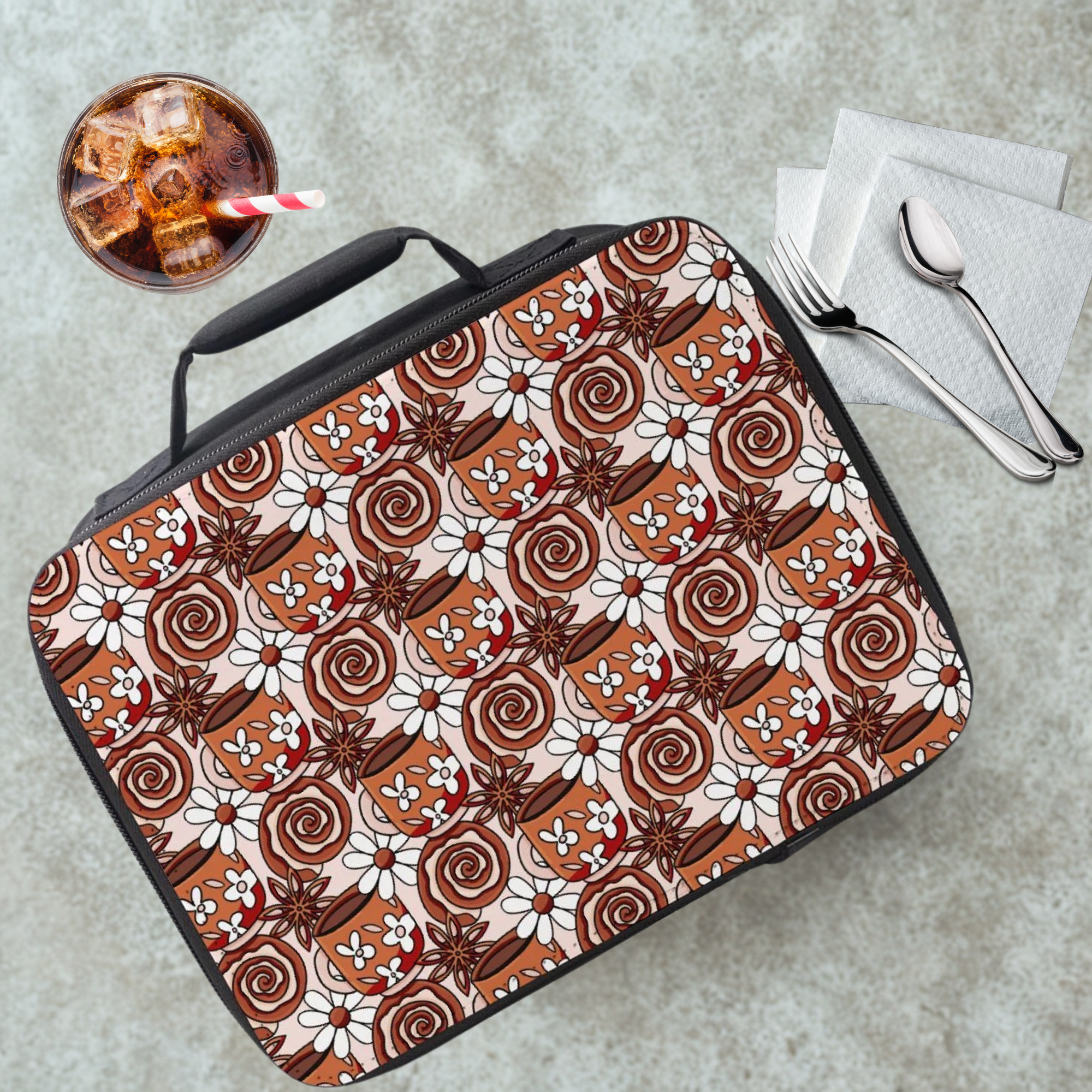  insulated lunch bag with cinnamon roll and coffee pattern on a cafeteria table with a drink and utensils