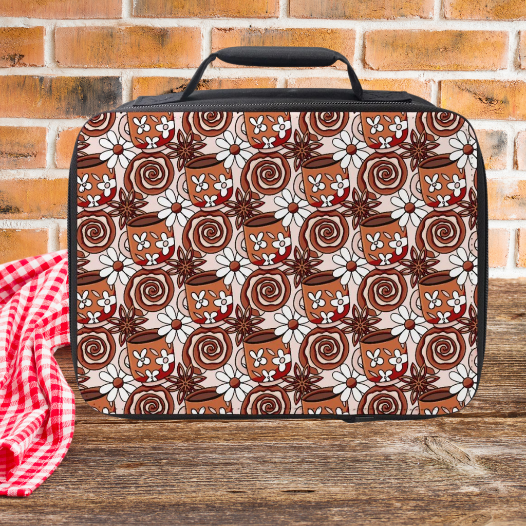 Coffee cup patterned lunch bag on a wooden picnic table with a brick wall background