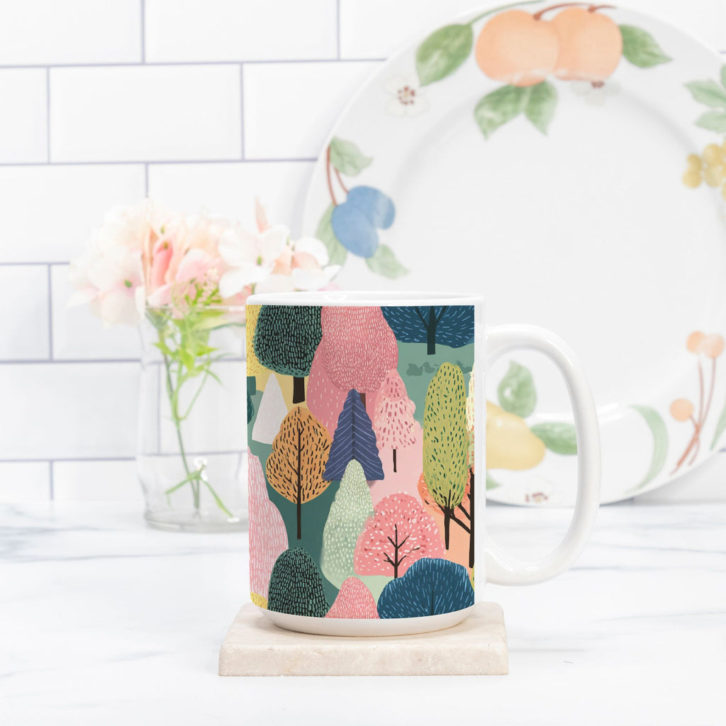 Mug with colorful forest design on a marble coaster, with a plate featuring fruit illustrations in the background.