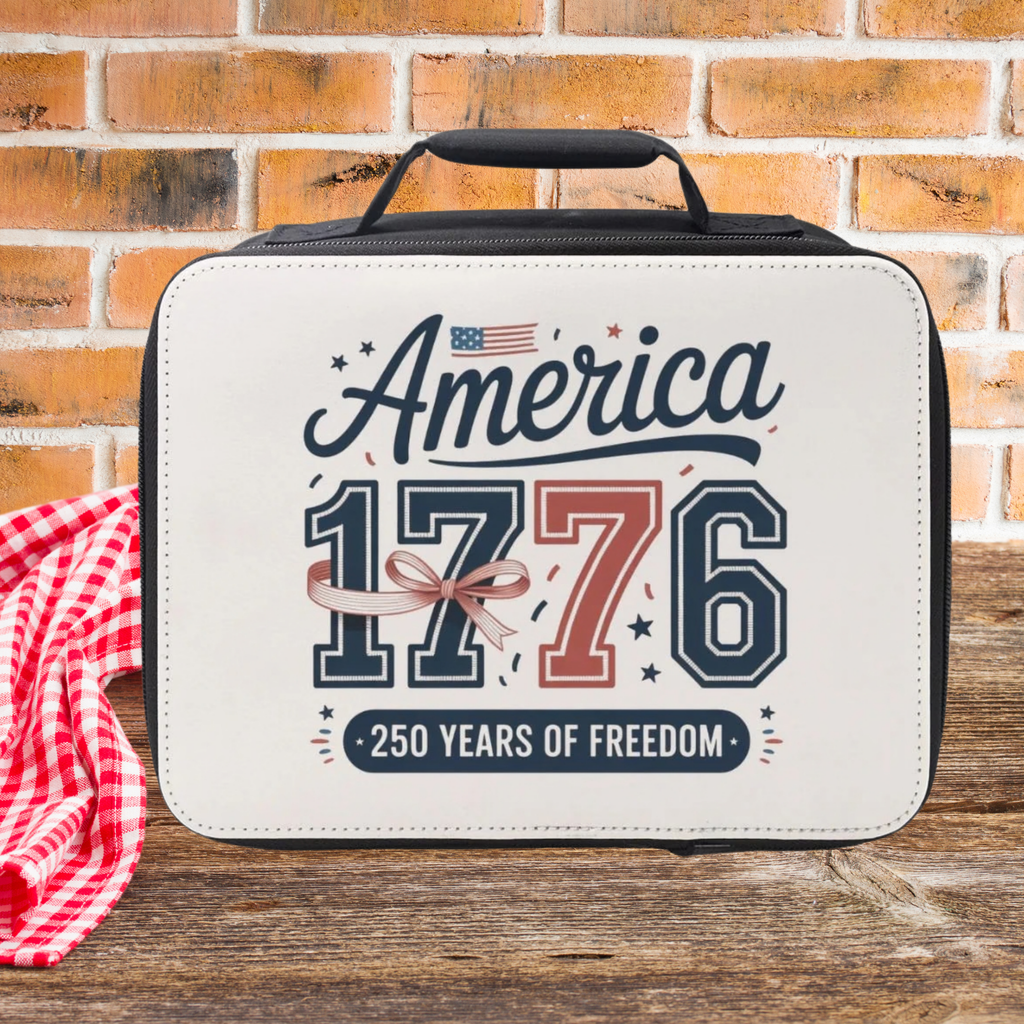 Lunch bag with 'America 1776 250 Years of Freedom' text on a wooden picnic table against a brick wall background