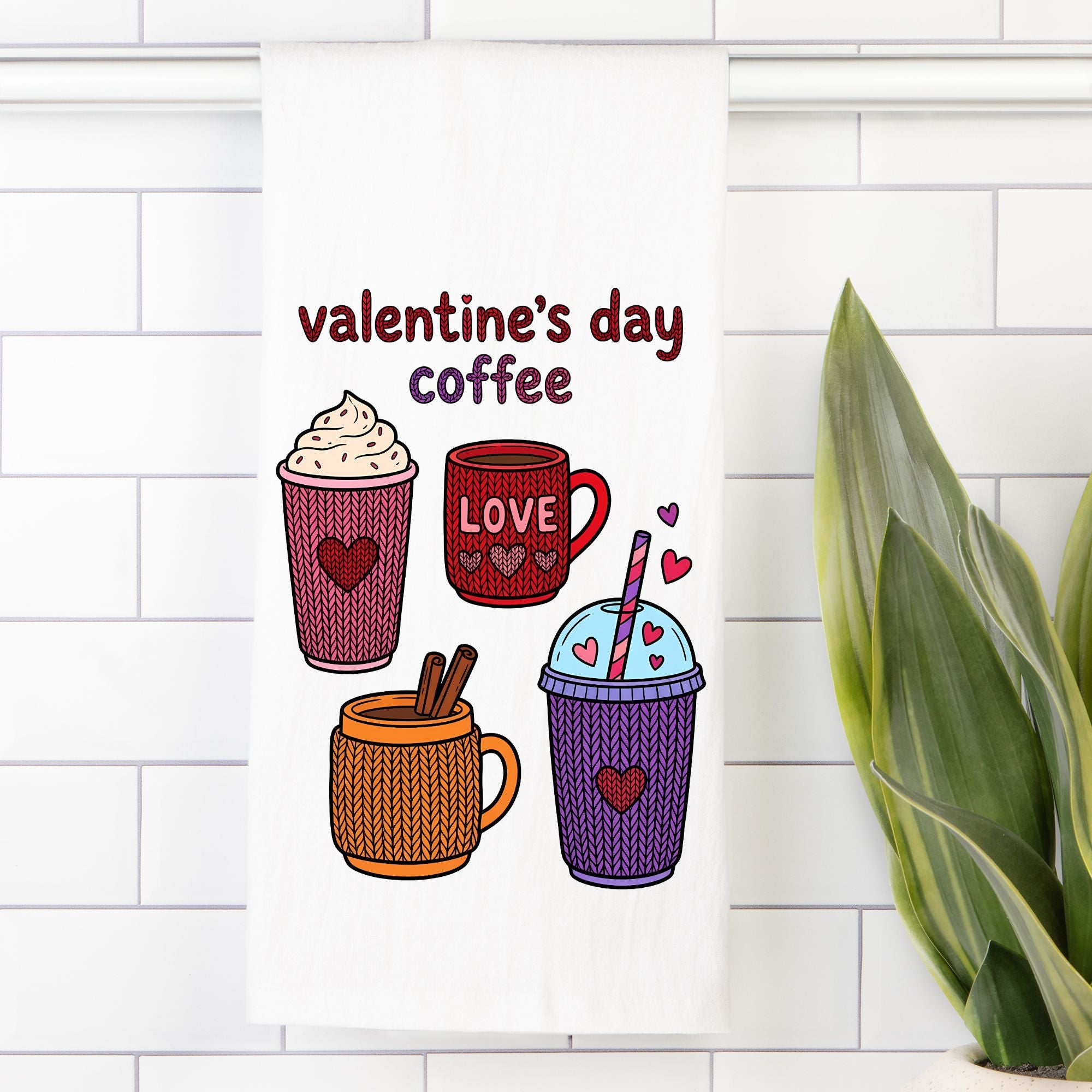 Tea Towel with Illustrations of Valentine's Day-themed coffee cups on a white tiled wall with a plant in the corner.