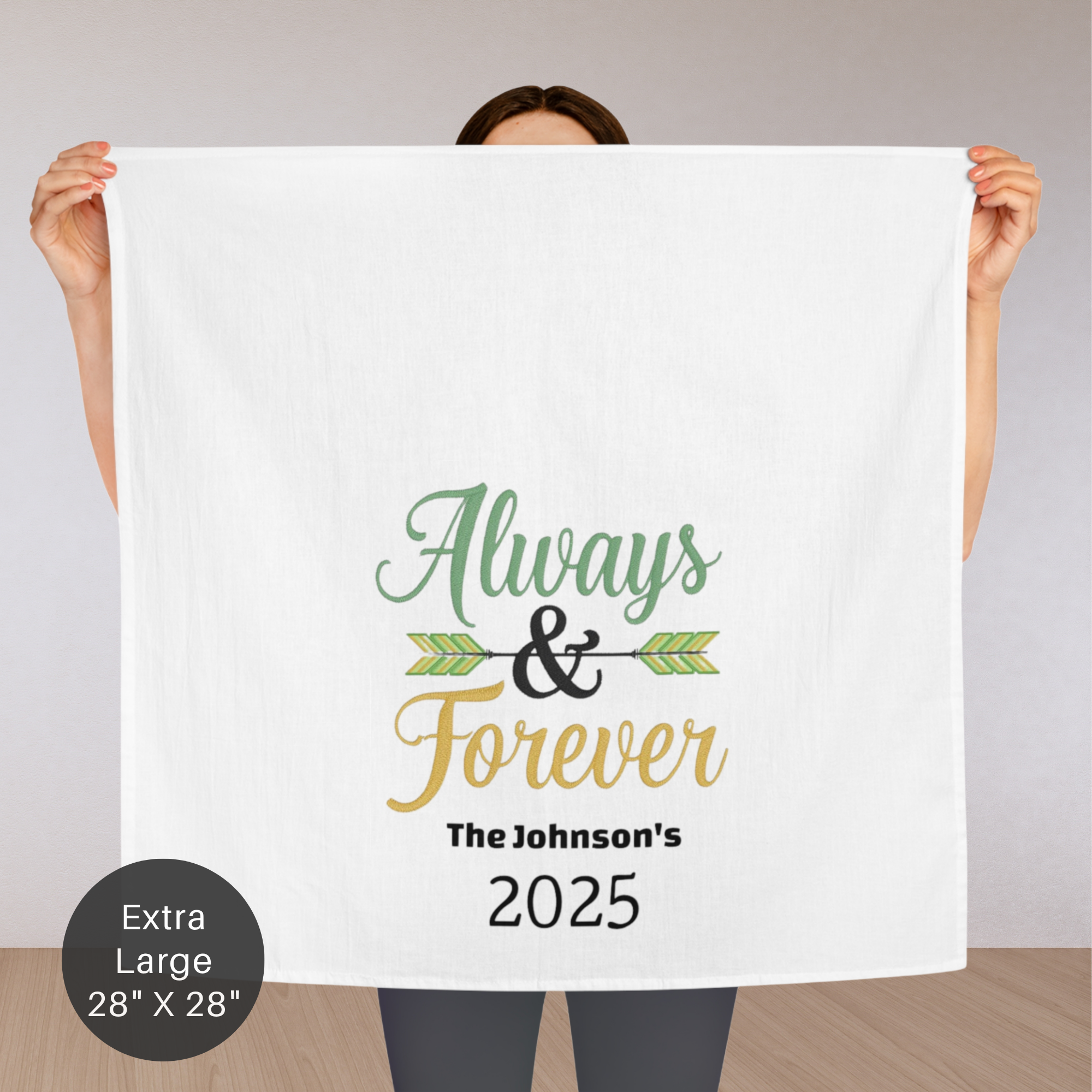 Person holding an extra large white tea towel with 'Always & Forever' text and 'The Johnson's 2025' on a plain background.