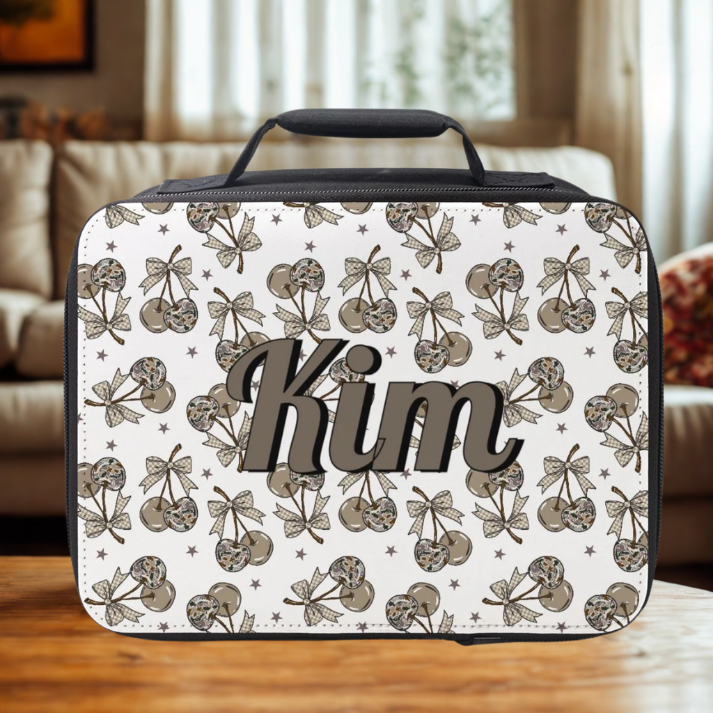 Lunch bag with camo cherry pattern and 'Kim' text on a wooden surface in a living room