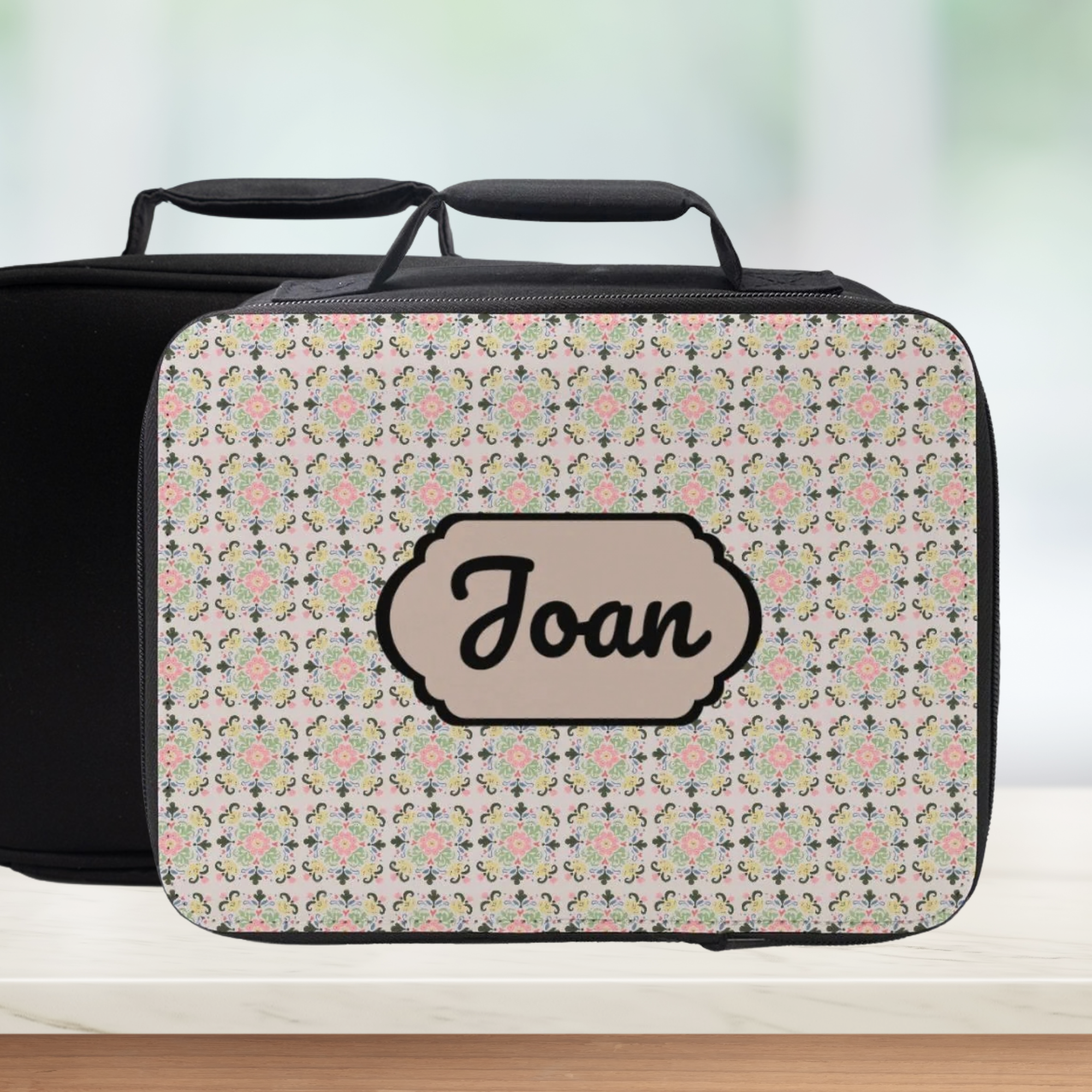 Patterned suitcase with 'Joan' name on a light background