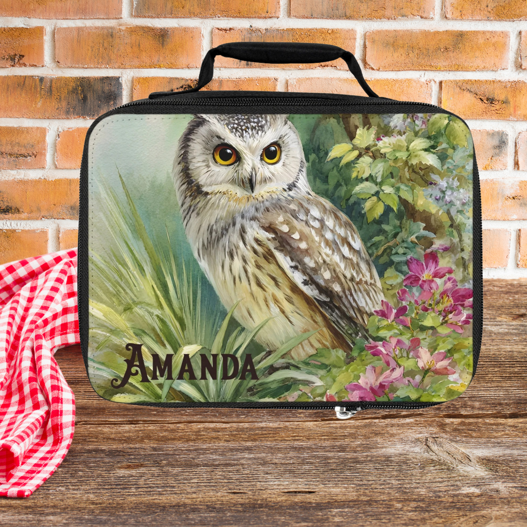 Lunch bag with an owl design and the name 'Amanda' on a wooden picnic table with a brick wall background.