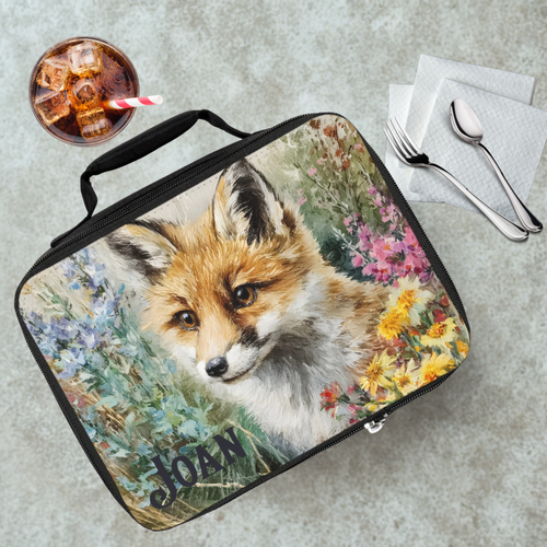 Lunch bag with a fox design on a table with a drink and utensils.