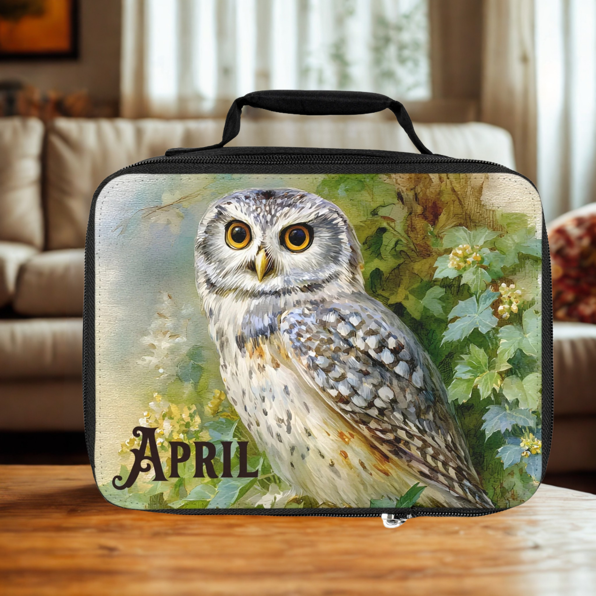  insulated lunch bag with an owl design and 'April' text on a wooden surface