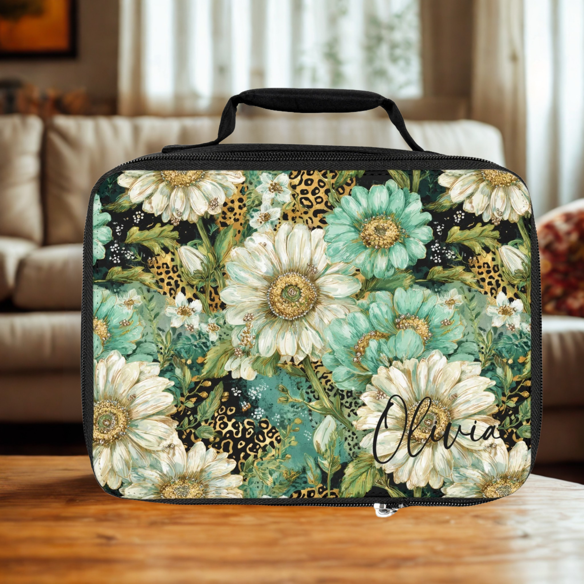 Floral patterned lunch bag with personalized name 'Olivia' on a wooden coffee table in a living room.