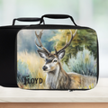 Black rectangular lunch bag with a deer painting design and 'Floyd' personalized text on a blurred nature background