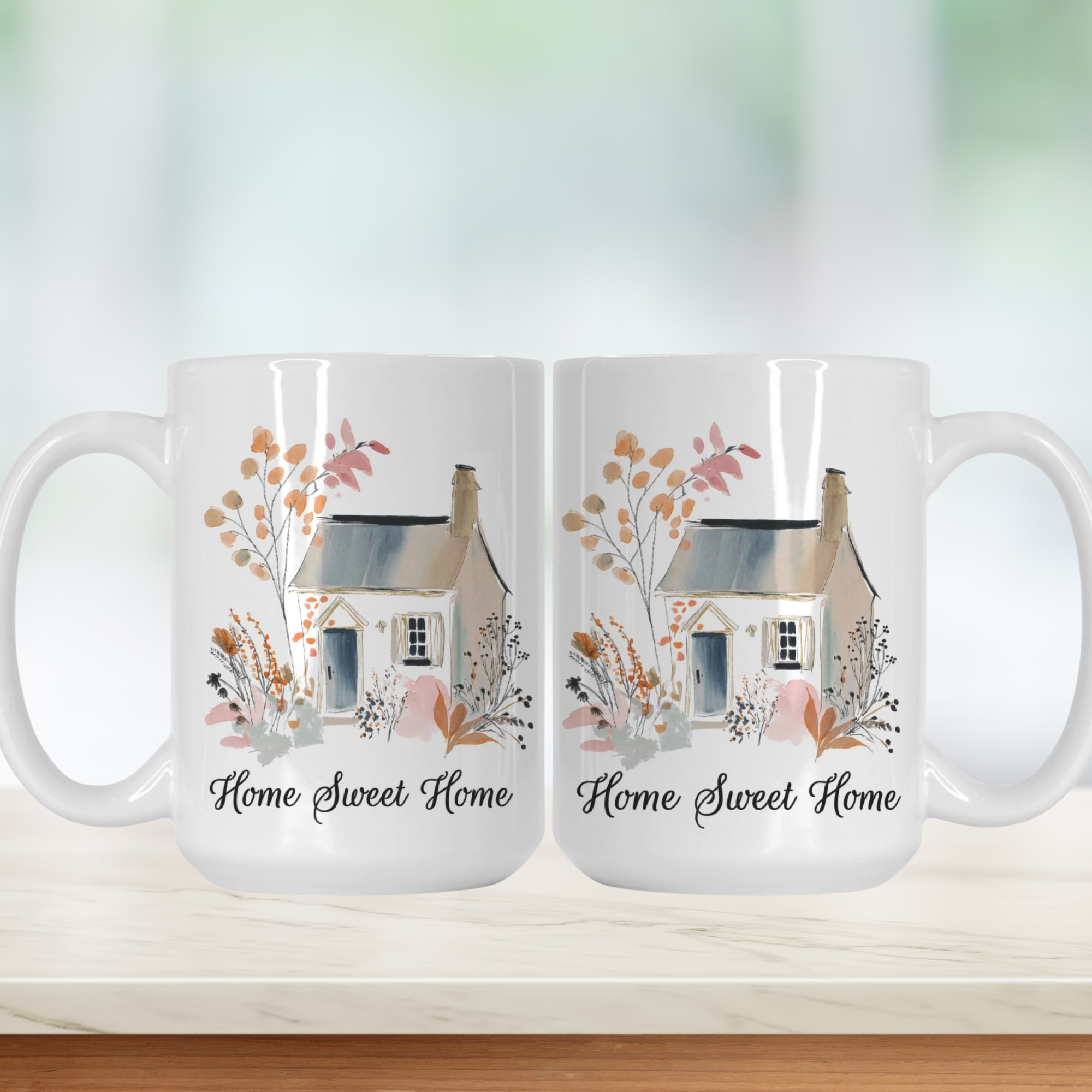 Two white mugs with a house illustration and 'Home Sweet Home' text on a light background.