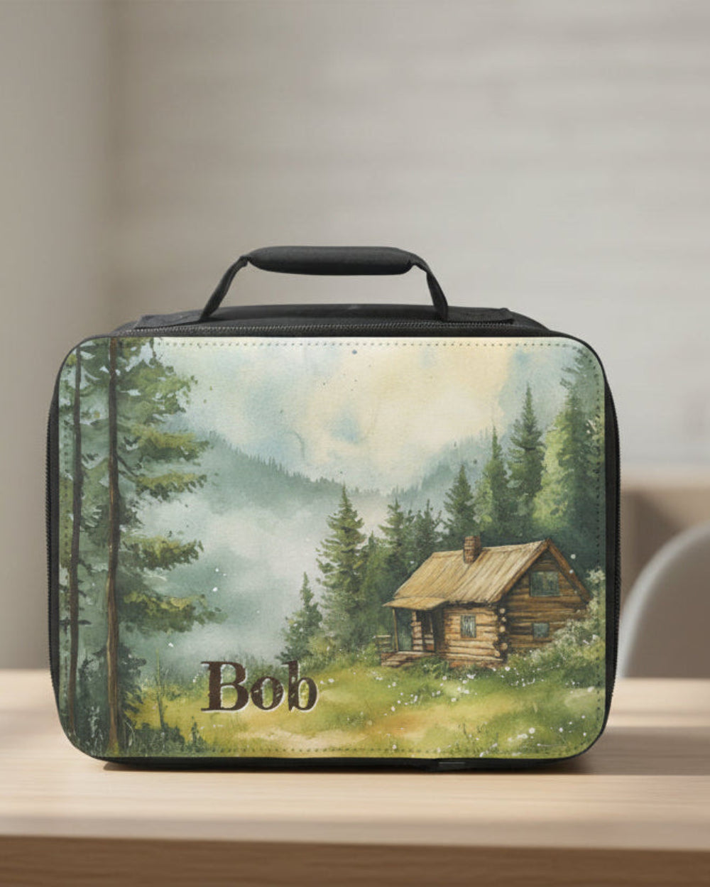  insulated lunch bag with a scenic design of a cabin and trees, featuring the name 'Bob'.