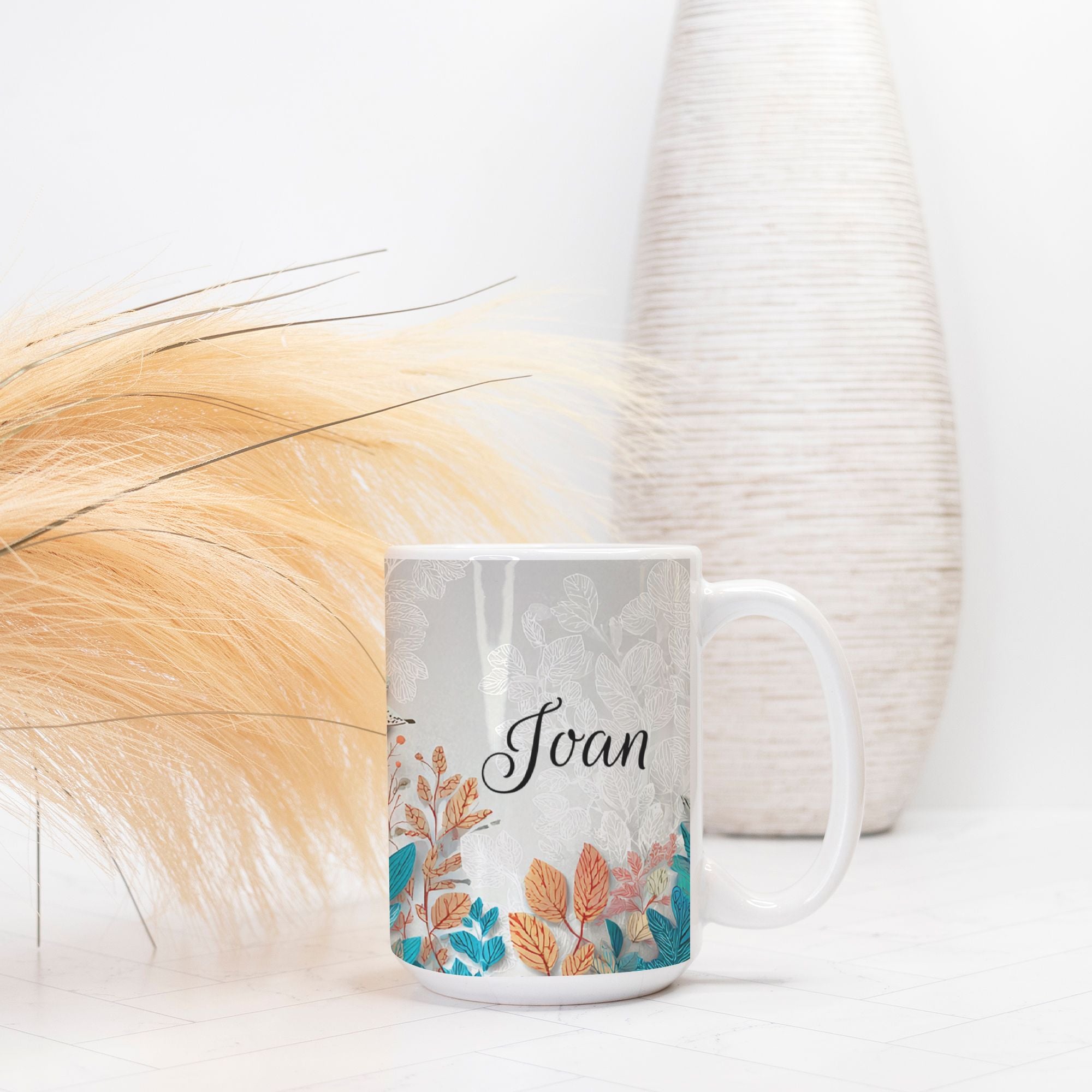 White mug with floral design and name 'Joan' on a light background