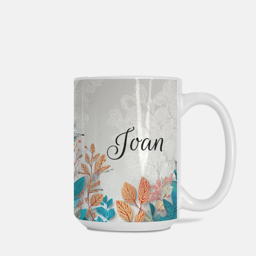 Mug with floral bird house design and name 'Joan' on a white background