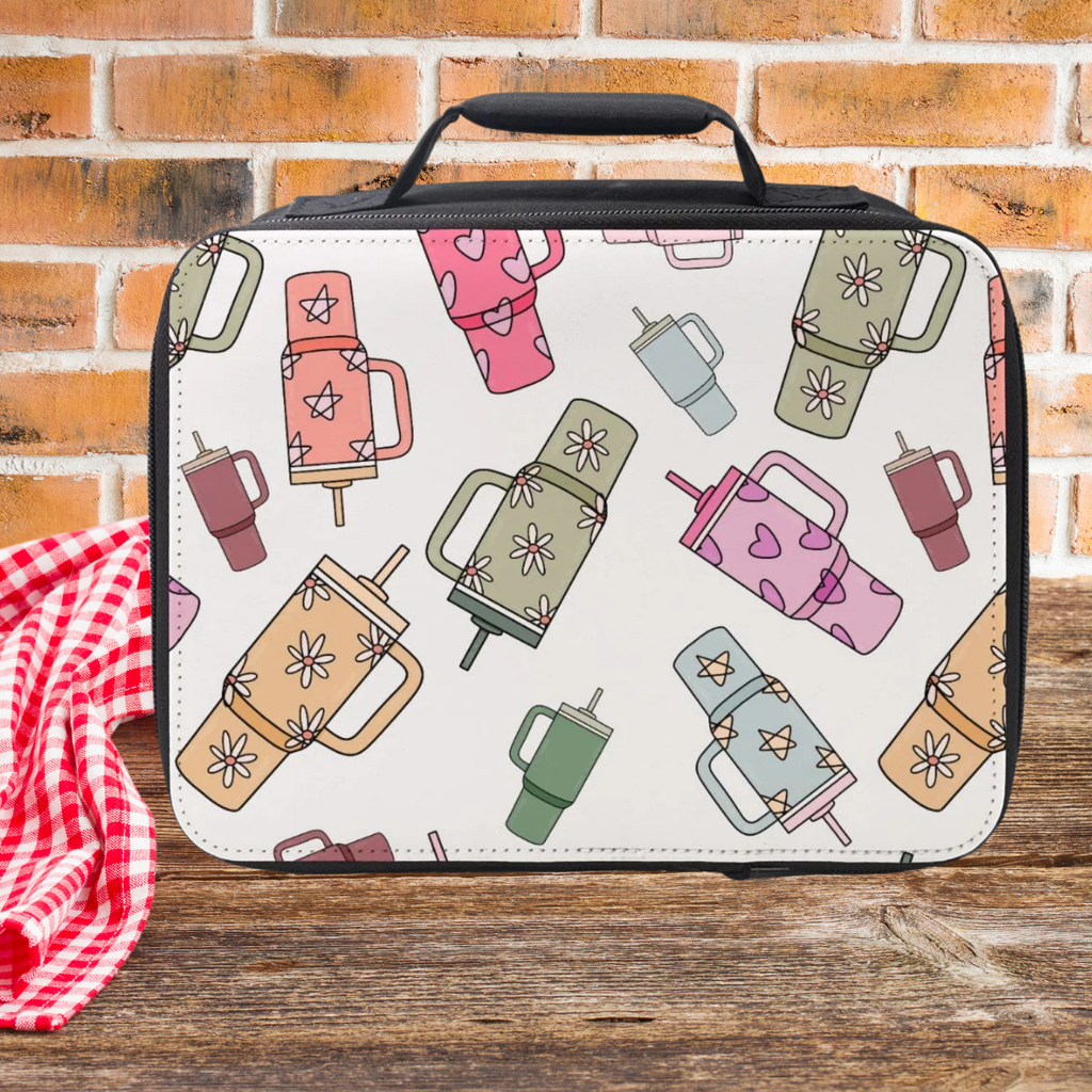Lunch bag with trendy cup pattern on a wooden picnic table against a brick wall background