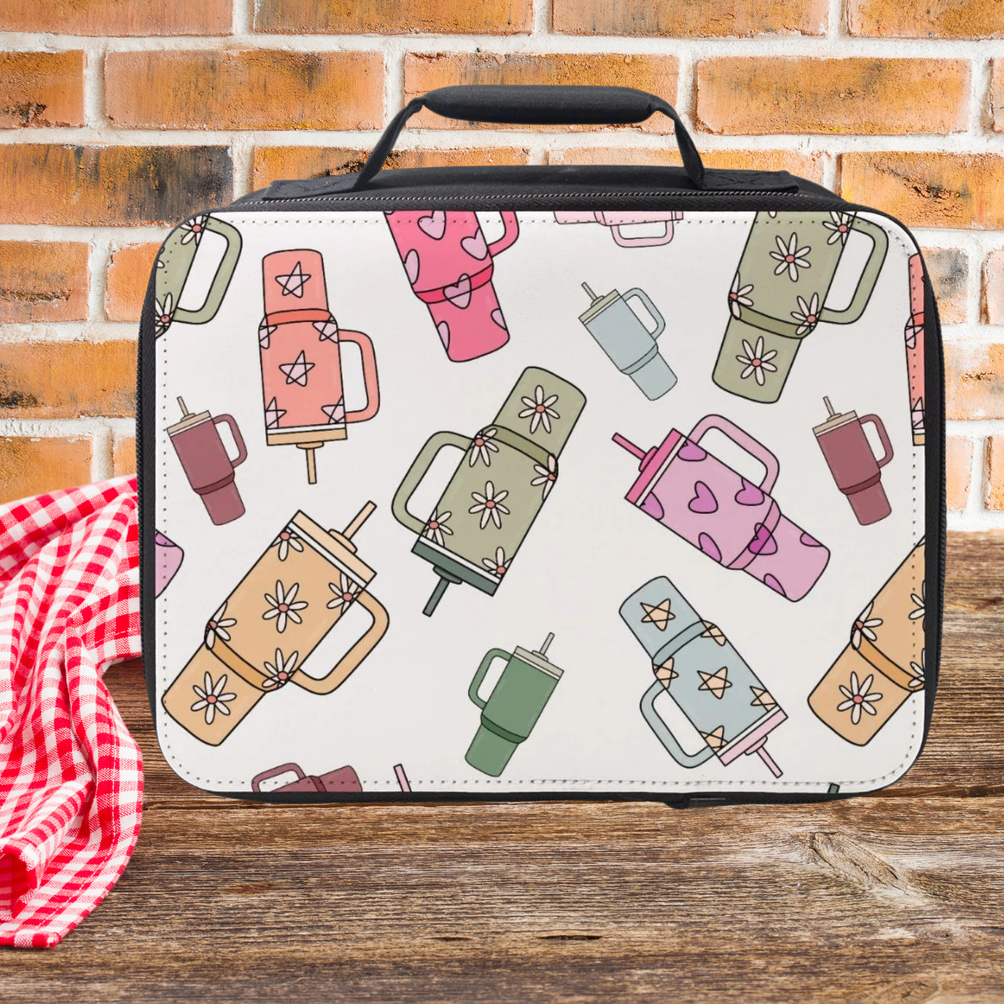 Lunch bag with trendy cup pattern on a wooden picnic table against a brick wall background