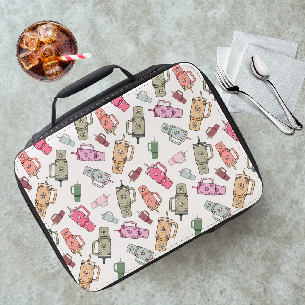 Lunch bag with trendy cup pattern on a cafeteria table with a drink and utensils.