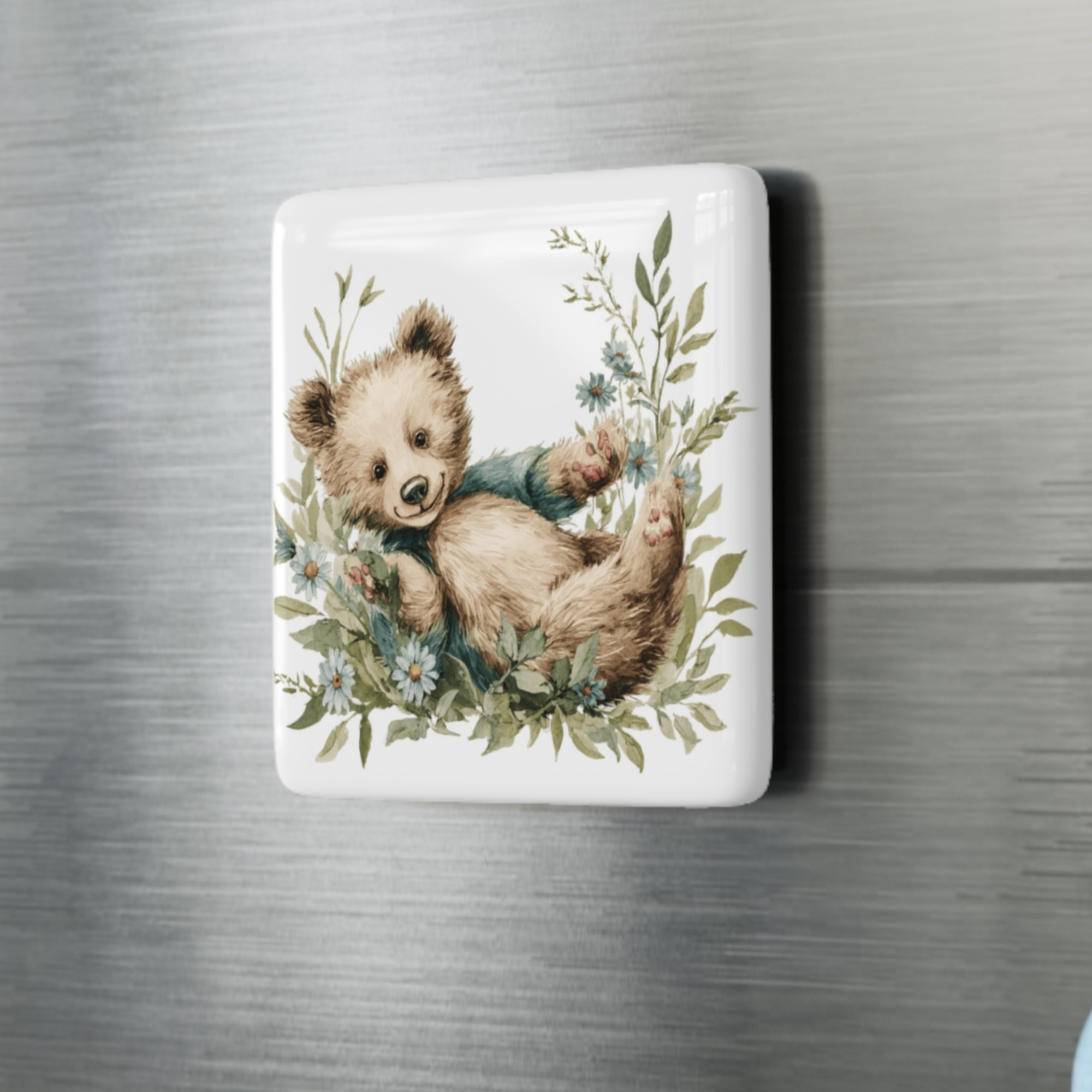 Fridge magnet with a bear illustration on a metallic surface