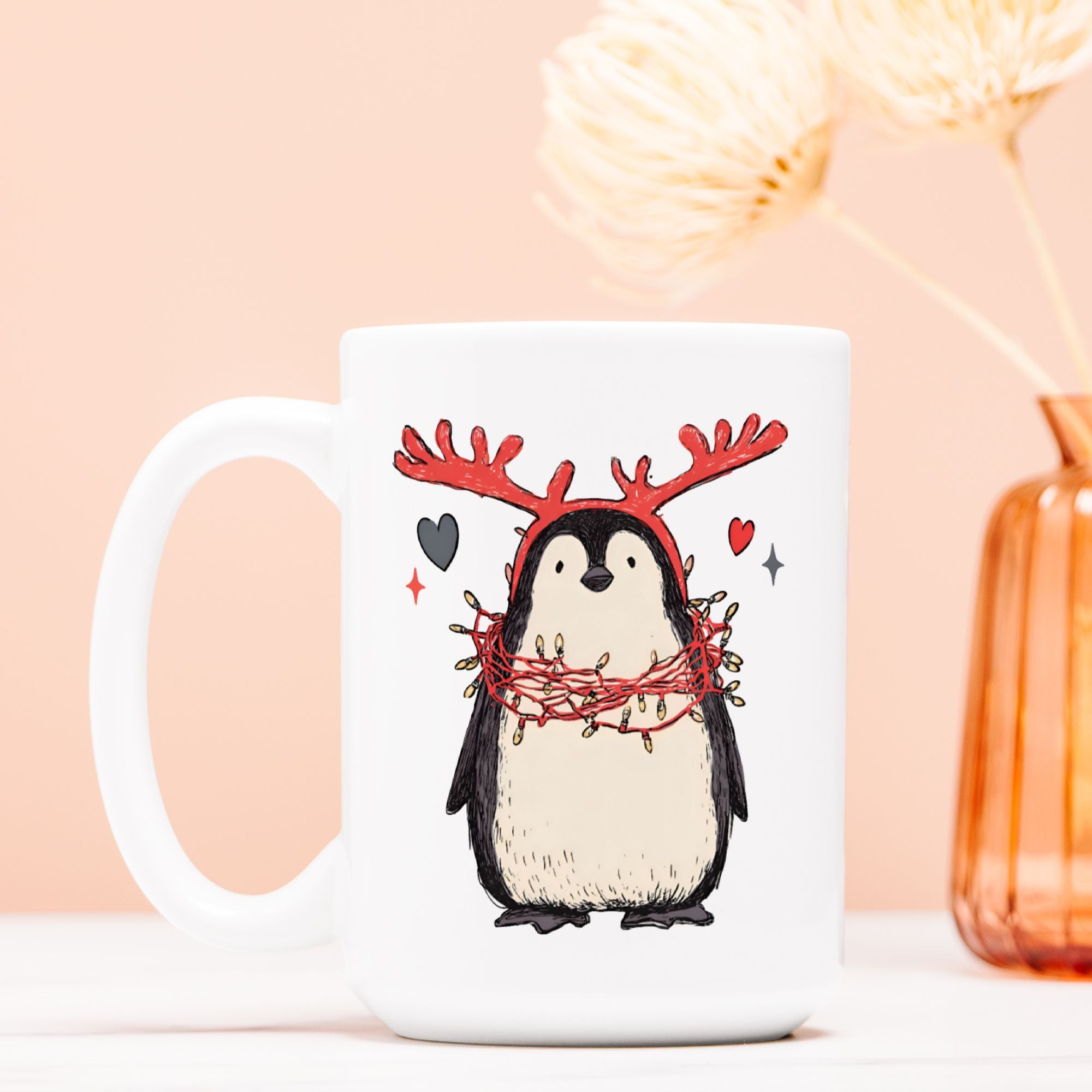 White mug with a penguin wearing reindeer antlers design on a light pink background