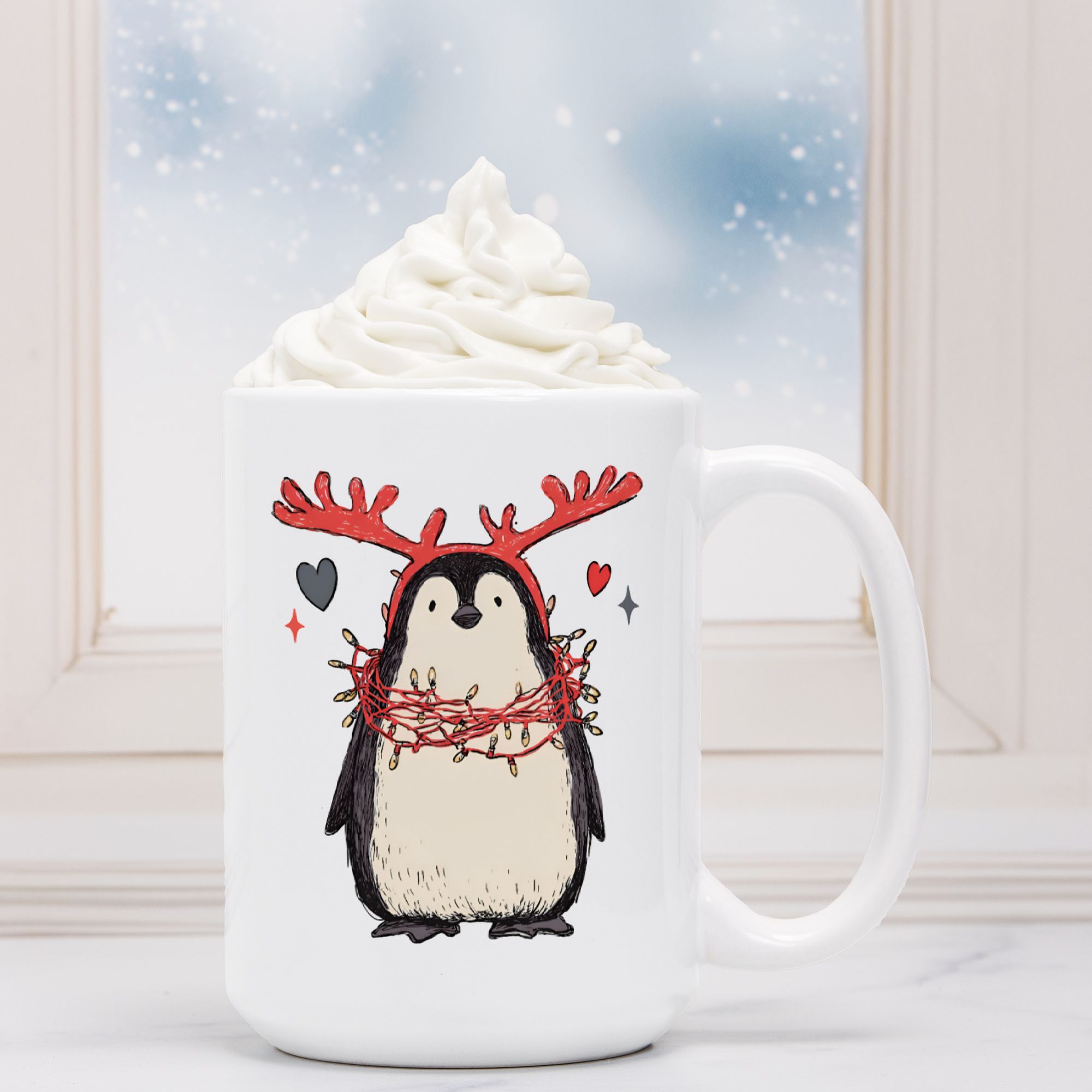White mug with a penguin wearing reindeer antlers design, filled with hot chocolate and whipped cream.