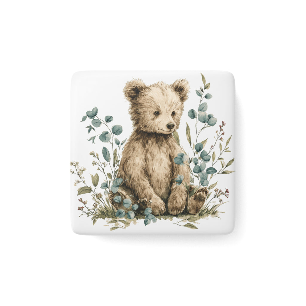 Fridge magnet with a bear illustration surrounded by leaves on a white background