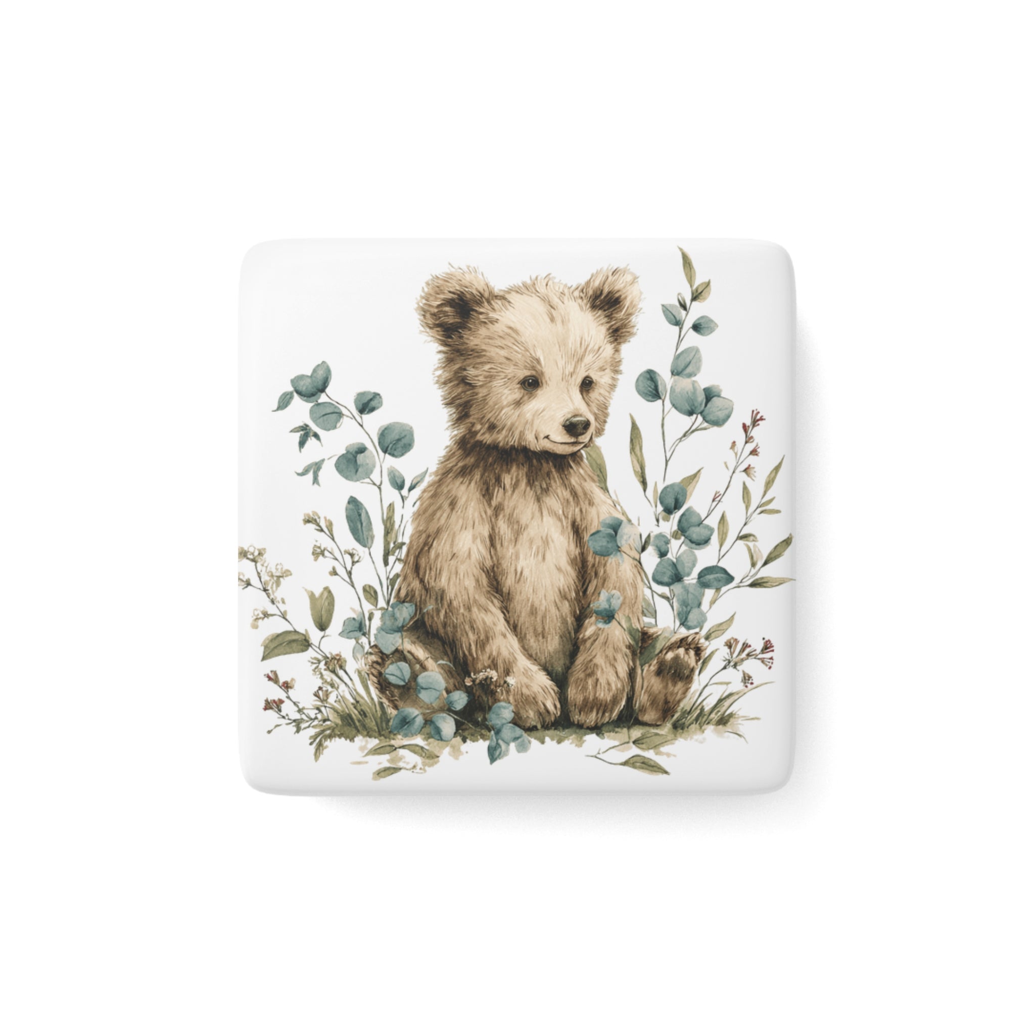 Fridge magnet with a bear illustration surrounded by leaves on a white background